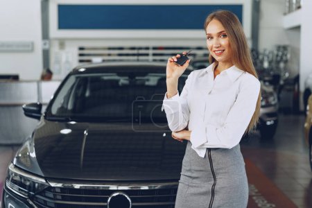 Photo for Young happy woman buyer/seller near the car with keys in hand - Royalty Free Image