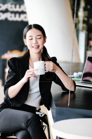 Téléchargez les photos : Une responsable marketing se repose avec une tasse de café avant de retourner au travail pour réduire la somnolence - en image libre de droit