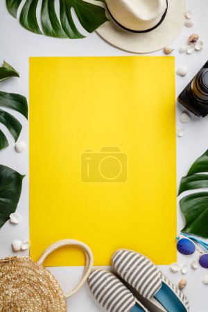 Téléchargez les photos : Chapeau de paille, appareil photo, sac, chaussures d'été, lunettes de soleil, coquillages et feuilles tropicales sur fond blanc et jaune, vue de dessus - en image libre de droit