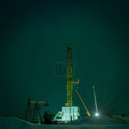 Photo for Drilling rig at night. Night view of a derrick drilling and oil pump jack. - Royalty Free Image