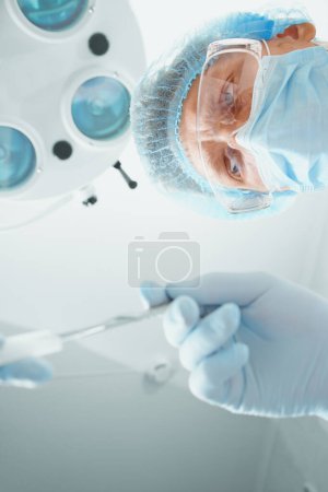 Téléchargez les photos : Homme chirurgien prend un scalpel - en image libre de droit