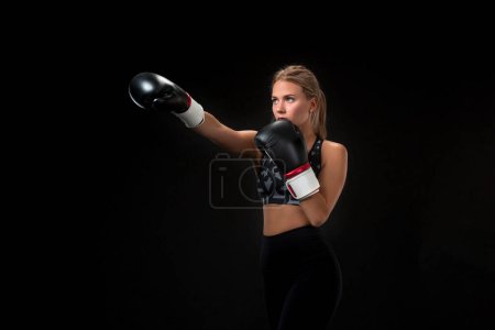 Téléchargez les photos : Belle athlète féminine en gants de boxe, en studio sur fond noir
. - en image libre de droit
