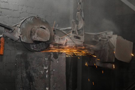 Foto de Equipo de molienda pesado suspendido en una cadena con un proceso de gancho y limpia tubos de hormigón armado de hierro fundido en el taller de una planta industrial - Imagen libre de derechos