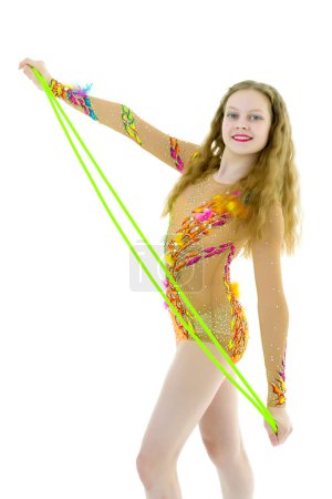 Téléchargez les photos : Une fille gymnaste effectue des exercices avec une corde à sauter. - en image libre de droit