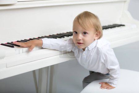 Foto de Niño en el estudio cerca de piano blanco
. - Imagen libre de derechos
