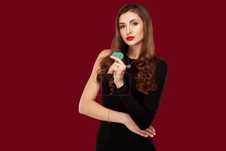 Photo for Pretty long hair woman in black dress holding chips for gambling - Royalty Free Image