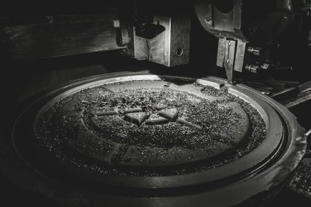 Foto de Chips después de procesar la escotilla de hierro fundido en la máquina de carrusel en el taller de la planta industrial - Imagen libre de derechos