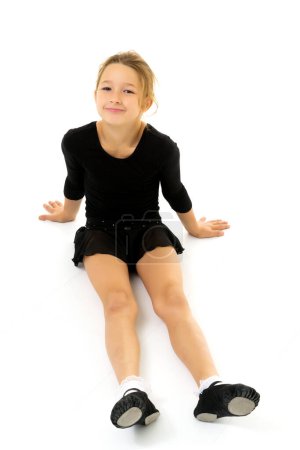 Foto de La pequeña gimnasta realiza un elemento acrobático en el suelo. - Imagen libre de derechos