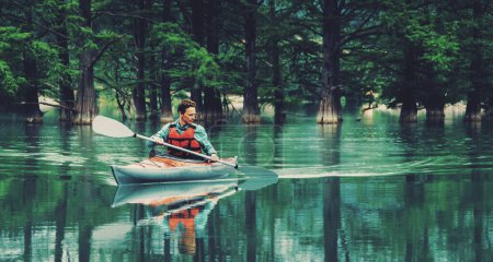 Téléchargez les photos : Homme pagayant en kayak sur le lac - en image libre de droit