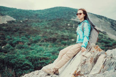 Photo for Traveler girl resting on rocks - Royalty Free Image