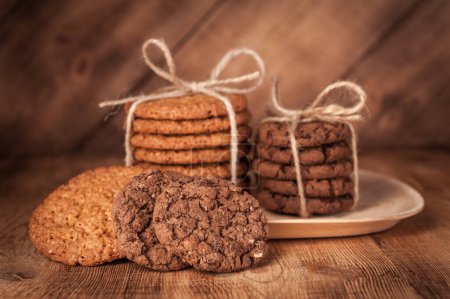 Téléchargez les photos : "Divers sablés, biscuits à l'avoine, biscuits aux pépites de chocolat sur table en bois rustique foncé
." - en image libre de droit