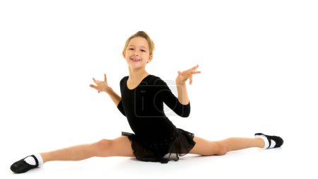 Photo for "Slender girl gymnast doing the twine. The concept of children's sport." - Royalty Free Image