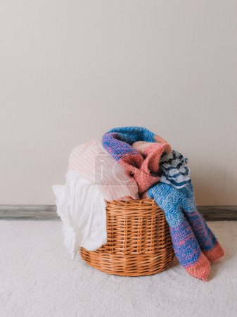 Photo for "Wicker basket with colorful underwear on a white carpet" - Royalty Free Image