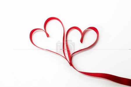 Photo for Two hearts tied together made of red ribbon - Royalty Free Image