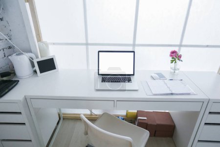 Foto de Moderno lugar de trabajo interior con ordenador portátil en colores blancos - Imagen libre de derechos