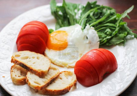 Foto de Primer plano de delicioso huevo frito con tomate y pan de fondo - Imagen libre de derechos