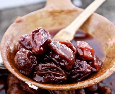 Téléchargez les photos : Gros plan de délicieuses prunes marinées dans un bol pour le fond - en image libre de droit