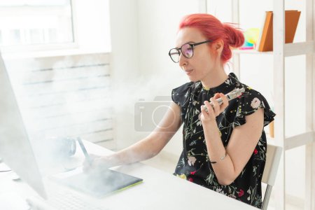 Foto de "Creativo, diseñador gráfico, concepto de personas - mujer creativa joven fumar un vapor mientras trabaja en una tableta gráfica
" - Imagen libre de derechos