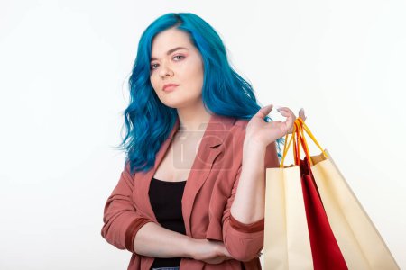 Photo for "Sale, shopaholic and consumer concept - beautiful girl with blue hair standing with shopping bags on white background" - Royalty Free Image