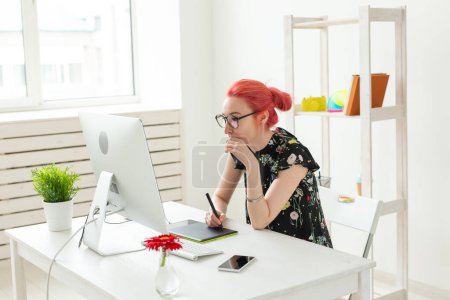 Foto de "Concepto creativo, ilustrador, gráfico y de personas: mujer empresaria creativa escribiendo o dibujando en una tableta gráfica mientras usa una computadora portátil en la oficina
" - Imagen libre de derechos