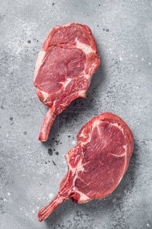 Foto de "Carne cruda de res Tomahawk (ternera) filete en la mesa del carnicero. Fondo gris. Vista superior" - Imagen libre de derechos