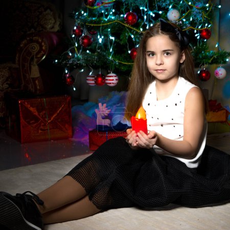 Photo for Little girl in a New Year costume with a candle. - Royalty Free Image