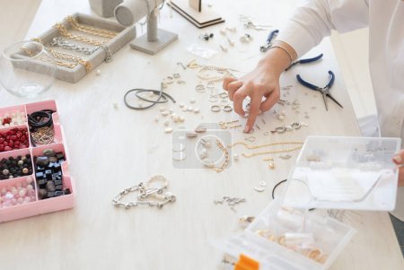 Téléchargez les photos : Créateur professionnel de bijoux fabriquant des bijoux faits à la main en atelier de studio close-up. Mode, créativité et concept fait main - en image libre de droit