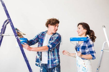 Foto de "Reparación, renovación y amor concepto de pareja - familia joven haciendo redecoración y pintando paredes juntos y riendo
." - Imagen libre de derechos