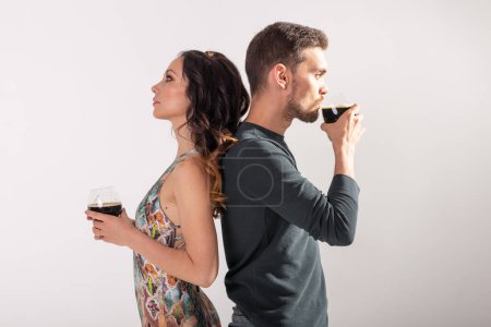 Téléchargez les photos : "Homme et femme tiennent des verres de bière noire sur fond blanc. Concept Oktoberfest
." - en image libre de droit