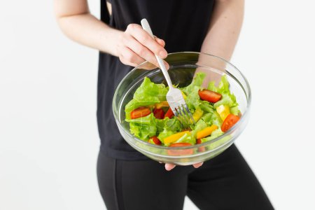 Téléchargez les photos : "Gros plan de la femelle tenant dans les mains une salade de légumes. Concept de saine alimentation." - en image libre de droit