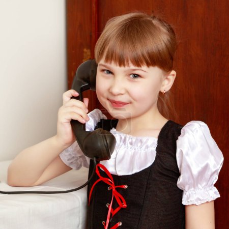 Photo for The girl is talking on the old phone. - Royalty Free Image