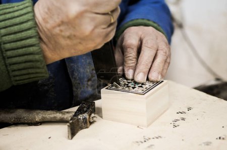 Foto de Fotógrafo de cerca de un artesano de taracea trabajando - Imagen libre de derechos