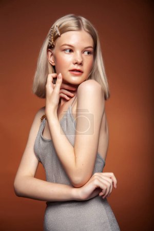 Photo for Young pretty blond girl posing on brown background, lifestyle people concept - Royalty Free Image