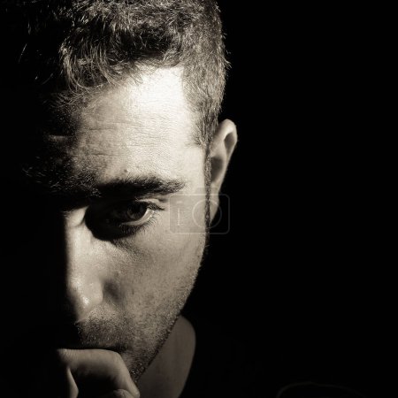 Photo for "Portrait of a man with half face on shadow" - Royalty Free Image