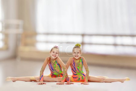 Foto de "Dos chicas gimnasta sentado en splits
." - Imagen libre de derechos