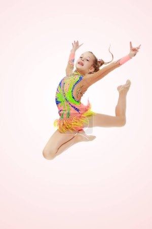 Photo for Girl gymnast performs a jump. - Royalty Free Image