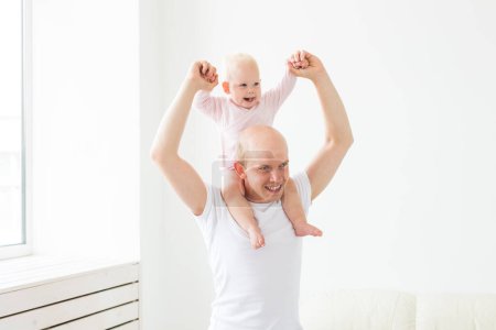 Téléchargez les photos : Paternité et concept familial - Père et petit bébé à l'intérieur à la maison, jouer
. - en image libre de droit