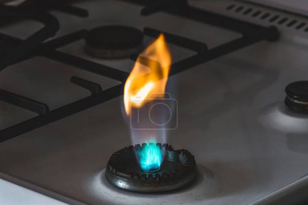 Téléchargez les photos : Brûleur à gaz avec flamme provenant d'un trou sur une cuisinière à gaz, gros plan - en image libre de droit