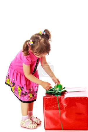 Téléchargez les photos : Petite fille regardant un cadeau - en image libre de droit