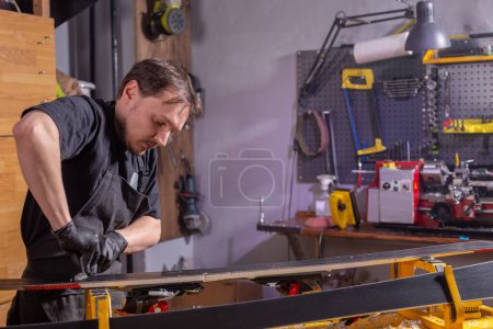 Photo for A man repairing the ski in the service - Royalty Free Image