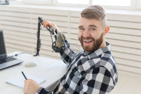 Photo for Radio host concept - Portrait of funny handsome bearded man sitting in front of microphone - Royalty Free Image