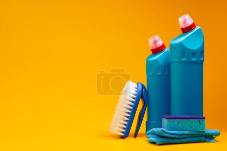 Téléchargez les photos : Nettoyage de maison bouteilles de détergent sur un fond jaune - en image libre de droit