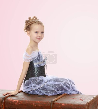 Téléchargez les photos : Petite fille assise sur une valise. - en image libre de droit