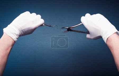 Foto de "Manos en guantes que sostienen herramientas dentales de cirugía
" - Imagen libre de derechos