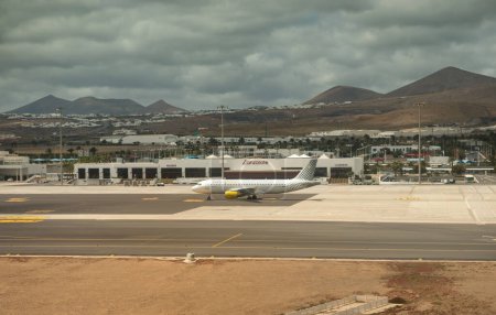 Photo for "Plane on the runway, cityscape and mountains, Spain" - Royalty Free Image