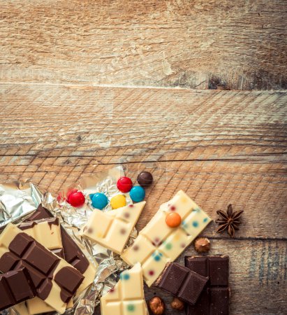 Foto de Chocolate y caramelos sobre fondo de madera - Imagen libre de derechos