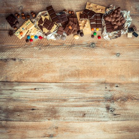 Foto de Chocolate y caramelos sobre fondo de madera - Imagen libre de derechos