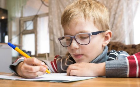 Photo for Focused first grader learning to write and doing homework - Royalty Free Image