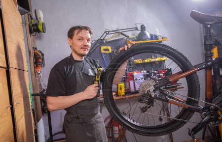 Photo for Service, repair, bike and people concept - Mechanic repairing a mountain bike in a workshop - Royalty Free Image