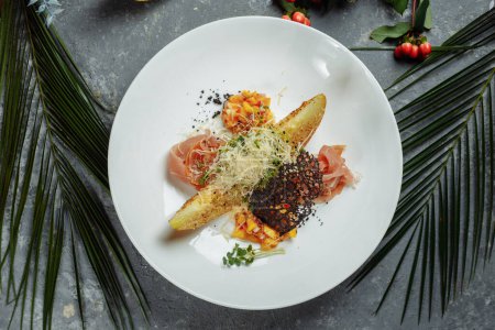 Téléchargez les photos : Melon cuit au four avec parmesan et hamon sur une assiette blanche - en image libre de droit